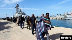 Les migrants arrivent à une base navale après avoir été secourus par la garde côtière libyenne à Tripoli, en Libye, le 13 mars 2018.