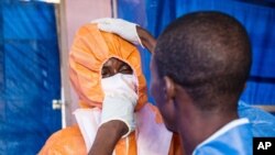 FILE: Healthcare workers wear protective gear before entering into a treatment center in Hastings, Freetown, Sierra Leone. Taken 10.5.2014