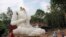 A Buddhist monk and villagers examine a damaged Buddha statue following an earthquake in Chiang Rai province, northern Thailand.