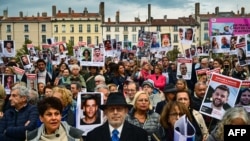 Učesnici skupa u Lionu u Francuskoj držae fotografije izraelskih talaca na komemoraciji žrtvama Hamasovog napada na Izrael 7. oktobra. (Foto: AFP/Olivier Chassignole)