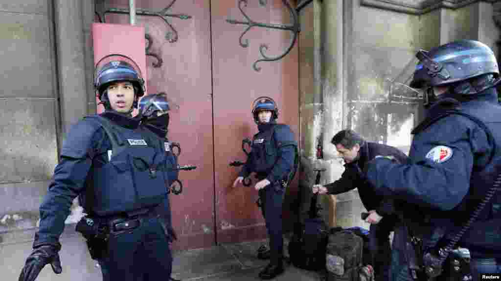 Des policiers français se déploient près de l&rsquo;entrée d&rsquo;une église au cours d&rsquo;un raid dans la banlieue parisienne de Saint-Denis, 18 novembre 2015.