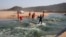Members of a hazardous waste cleanup crew collect dead fish after chemicals entered the water system from a warehouse which was burned during days of looting following the imprisonment of former South African President Jacob Zuma, in Durban, July 17, 2021