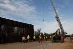 FILE - Workers break ground on new border wall construction about 20 miles west of Santa Teresa, New Mexico, Aug. 23, 2019.