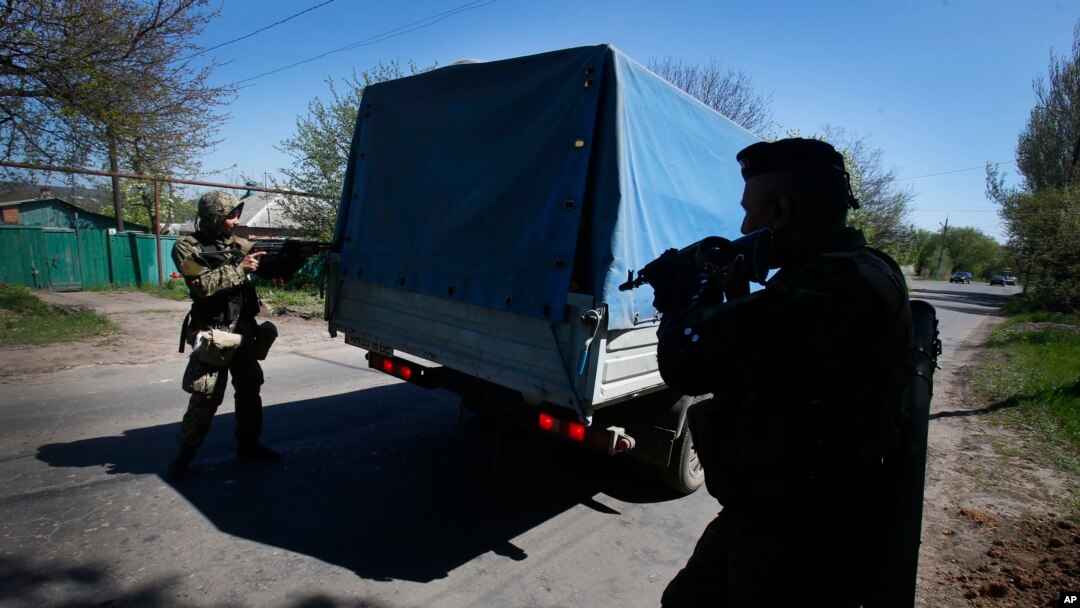 Kelompok bersenjata pro Rusia memeriksa sebuah truk dekat Slovyansk, Ukraina bagian timur, 25 April 2014.