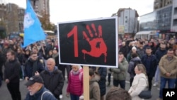 People stand in silence to commemorate the 15 victims of a railway roof collapse that occurred one month ago, in Novi Sad, Serbia, Dec. 1, 2024.