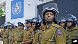 Police officers stand guard in front of the UN head office during a protest in Colombo, Sri Lanka, March 2, 2012. The UN Human Rights Council is currently debating a proposed resolution to probe alleged war crimes in the final months of the Sri Lankan civ