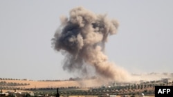 Smoke billows during pro-regime bombardments in the area of Maar Hitat in Syria's northern Idlib province, Aug. 20, 2019.