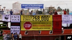 Cambodian non-governmental organization (NGOs) activists shout slogans during a protest against a proposed Don Sahong dam, in a tourist boat along the Tonle Sap river, in Phnom Penh, Cambodia, Sept. 11, 2014.