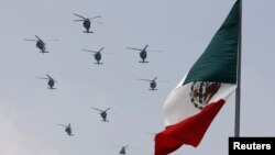 Helicópteros de la Fuerza Aérea de México vuelan en formación durante un desfile militar el Día de la Independencia que celebra en la plaza del Zócalo de la Ciudad de México.