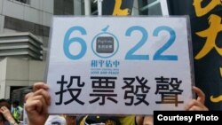 香港市民在中联办前高举和平占中运动6/22全民投票牌（网络图片）