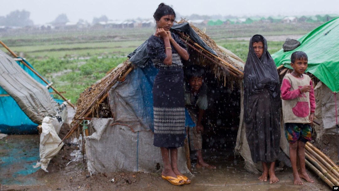 FILE - Internally displaced Rohingya stand outside their makeshift tent in a camp in Sittwe in Myanmar's northwestern Rakhine state in 2013.