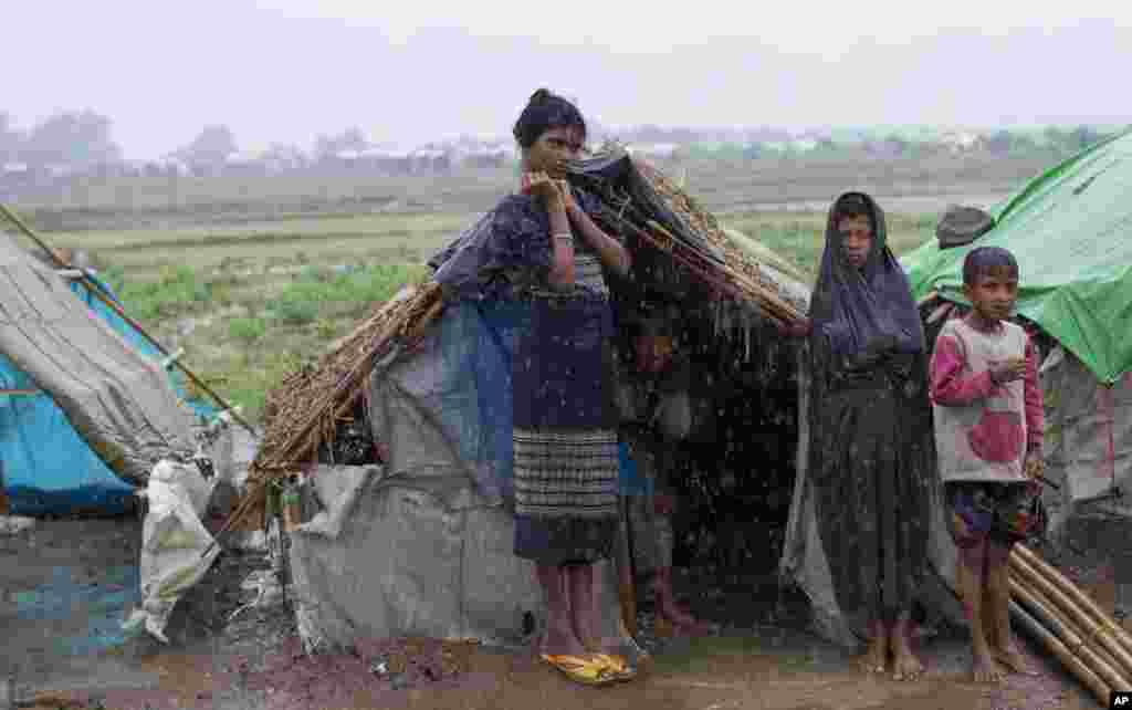 Para pengungsi Rohingya berdiri di luar tenda mereka di kamp di Sittwe, negara bagian Rakhine, Burma (14/5). (AP/Gemunu Amarasinghe)