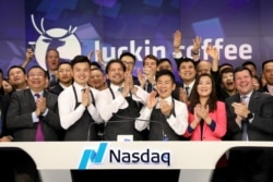 FILE - Jenny Qian Zhiya, CEO of Luckin Coffee, and Charles Zhengyao Lu, non-executive chairman of Luckin Coffee, ring the Nasdaq opening bell with employees to celebrate the company's IPO at the Nasdaq Market site in New York, May 17, 2019.