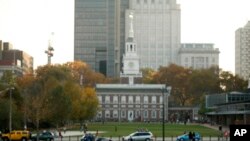 Seorang pria membaca koran di dekat Independence Hall, Philadelphia (6/11). Philadelphia menjadi kota pertama di Amerika yang menyandang Kota Warisan Dunia. 