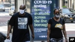 Pedestrians wear protective masks during the coronavirus pandemic, in New York City, May 15, 2020. 
