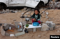 A Palestinian miss  sits connected  the crushed  adjacent  to a car   destroyed successful  a Israeli subject   violative  successful  Khan Younis successful  the confederate  Gaza Strip, Nov. 29, 2024.