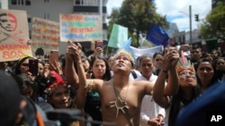 FILE - Indigenous demonstrators join a protest outside the Brazilian Embassy to call on Brazil's President Jair Bolsonaro to act to protect the Amazon rainforest, in Bogota, Colombia, Aug. 23, 2019.