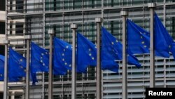 FILE - European Union flags are seen outside the European Commission headquarters in Brussels, Sept. 10, 2014. 