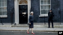 FILE - British Prime Minister Theresa May is seen walking outside 10 Downing Street in London, Nov. 9, 2016. A legislative aide was photographed in Downing street carrying hand-written notes some say offer insights into London's Brexit strategy.