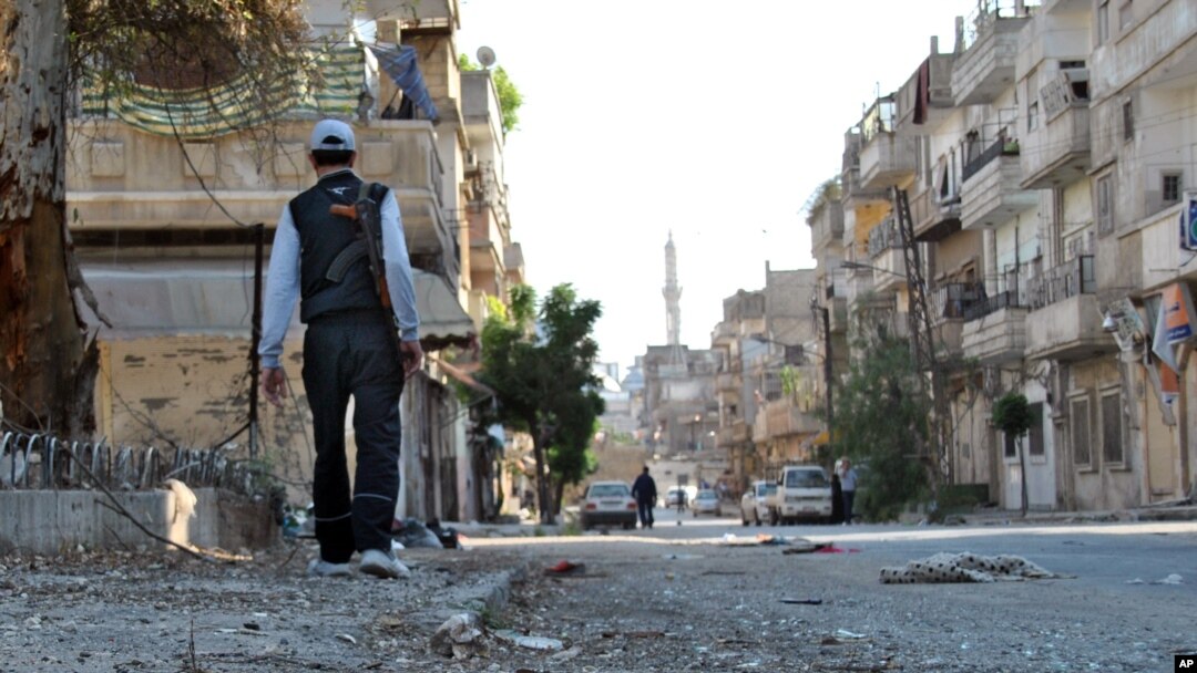 A Syrian rebel walks in Khaldiyeh neighborhood, Homs province, May 15, 2012.