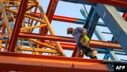 An Iranian construction worker walks on a steel I-beam at a building site in Baghdad, June 28, 2018.