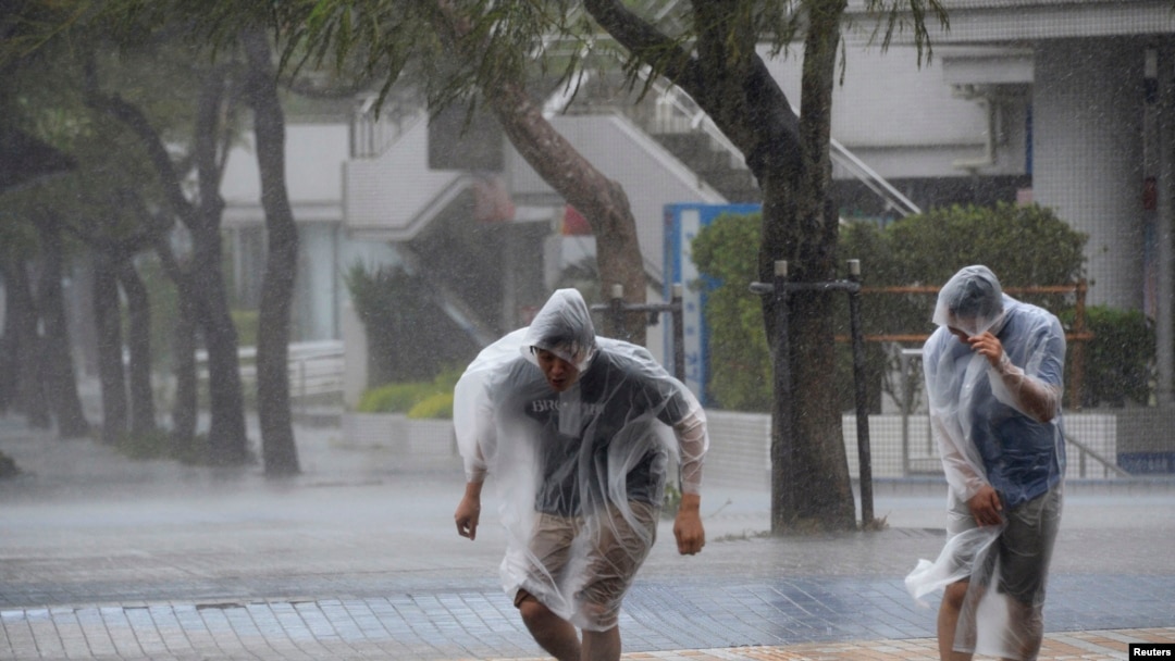 Warga di jalanan kota Naha di Okinawa, Jepang, di tengah badai Vongfong (11/10).
