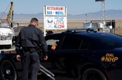 Law enforcement officials stand outside of the Little A'Le'Inn, Wednesday, Sept. 18, 2019, in Rachel, Nev.