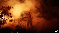 Bomberos de Los Angeles caminan a lo largo de la línea de fuego en Groveland, cerca de Yosemite.