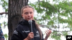Greta Thunberg, a 16-year-old Swedish climate activist, speaks in front of a crowd of people after sailing in New York harbor aboard the Malizia II, Wednesday, Aug. 28, 2019.