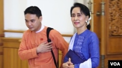 Bà Aung San Suu Kyi bước vào trụ sở Quốc hội ở Naypyitaw với một thành viên đảng NLD.