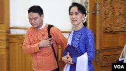 Aung San Suu Kyi walks with a NLD member into parliament in Naypyitaw, Myanmar, March 11, 2016. (Z. Aung/VOA News)