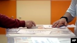 FILE - An early voter casts his vote in the polling station on the outskirts of Sofia, Bulgaria, June 9, 2024.