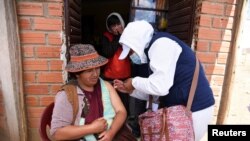 Una mujer boliviana recibe una vacuna contra COVID-19 en una campaña de vacunación de casa por casa en El Alto, Bolivia, el 17 de septiembre de 2021.