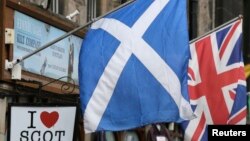 FILE - The Scottish Saltire flag (L) and the British Union flag are seen outside a shop in the centre of Edinburgh, Scotland on Sept. 12, 2014. 