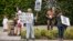 FILE - Los Angeles community members wait for Hillary Clinton's motorcade as they show their opposition to the Trans-Pacific Partnership in Beverly Hills, Calif., May 7, 2015.