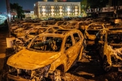 FILE - The carcasses of the cars burned by protesters the previous night during a demonstration against the shooting of Jacob Blake are seen on a used-cars lot in Kenosha, Wisconsin, Aug. 26, 2020.