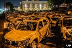 FILE - The carcasses of the cars burned by protesters the previous night during a demonstration against the shooting of Jacob Blake are seen on a used-cars lot in Kenosha, Wisconsin, Aug. 26, 2020.