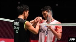 Pebulutangkis Jepang Kento Momota menyalami Jonatan Christie dari Indonesia pada akhir laga final tunggal putra turnamen Jepang Terbuka di Tokyo, 28 Juli 2019. (Foto: AFP)