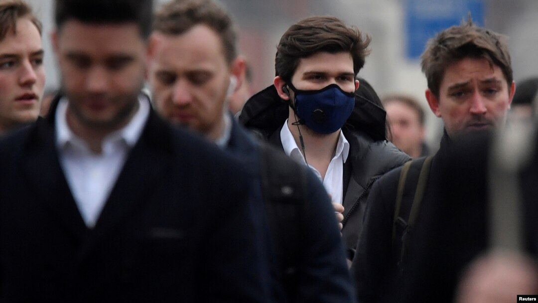 Para pekerja, beberapa mengenakan masker, menyeberangi Jembatan London, saat jam sibuk di London, 5 Maret 2020. (Foto: Reuters)