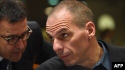 Greece's Finance Minister Yanis Varoufakis (R) speaks with a Greek delegation member an economic and financial affairs council (ECOFIN) at the European Council in Brussels, March 10, 2015.