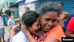 Les personnes vivant près de l'église attaquée hier quittent leurs maisons pendant que l'armée tente de désamorcer une fourgonnette présumée avant qu'elle n'explose à Colombo, au Sri Lanka, le 22 avril
