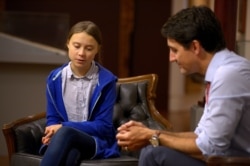 FILE - Canada's Prime Minister Justin Trudeau greets Swedish climate change teen activist Greta Thunberg before a climate strike march in Montreal, Quebec, Canada, Sept. 27, 2019.