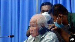 Khieu Samphan, left, the former head of state for the Khmer Rouge, sits in a courtroom during a hearing at the U.N.-backed war crimes tribunal in Phnom Penh, Cambodia, Aug. 19, 2021.