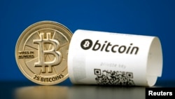 FILE - A Bitcoin (virtual currency) paper wallet with QR codes and a coin are seen in an illustration picture taken at La Maison du Bitcoin in Paris, France, May 27, 2015.