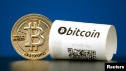 FILE - A Bitcoin (virtual currency) paper wallet with QR codes and a coin are seen in an illustration picture taken at La Maison du Bitcoin in Paris, France, May 27, 2015.