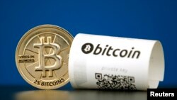 A Bitcoin (virtual currency) paper wallet with QR codes and a coin are seen in an illustration picture taken at La Maison du Bitcoin in Paris, France, May 27, 2015.