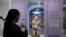 FILE - A gallery assistant takes a picture of a statue during a press preview ahead of the opening of the exhibition ReThinking Collections at the AfricaMuseum in Tervuren, northwest of Brussels, on January 17, 2024.