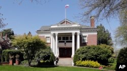 FILE - A Russian flag flies from the roof of the former Russian consul general's residence in Seattle, April 25, 2018. U.S. State Department officials said they respectfully lowered the Russia flag Saturday from the Russian consul-general residence proper