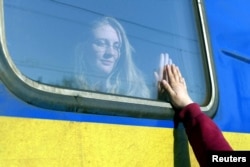 FILE - A woman says goodbye to her relative aboard a train traveling to Przemysl, Poland, amid Russia's invasion of Ukraine, in Odesa, Ukraine, April 25, 2022. (REUTERS/Igor Tkachenko)