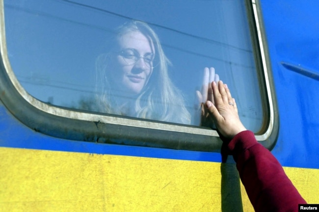 FILE - A woman says goodbye to her relative aboard a train traveling to Przemysl, Poland, amid Russia's invasion of Ukraine, in Odesa, Ukraine, April 25, 2022. (REUTERS/Igor Tkachenko)